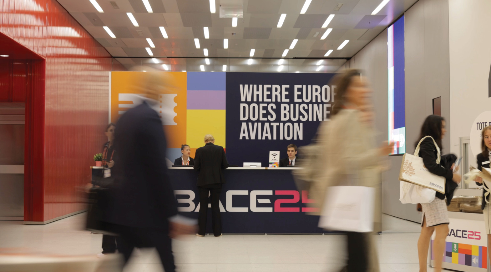 EBACE 2025 registration desk with attendees arriving at business aviation event