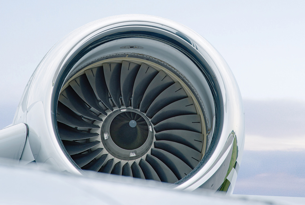 Close-up of private jet engine turbine above clouds, showcasing aviation power and engineering