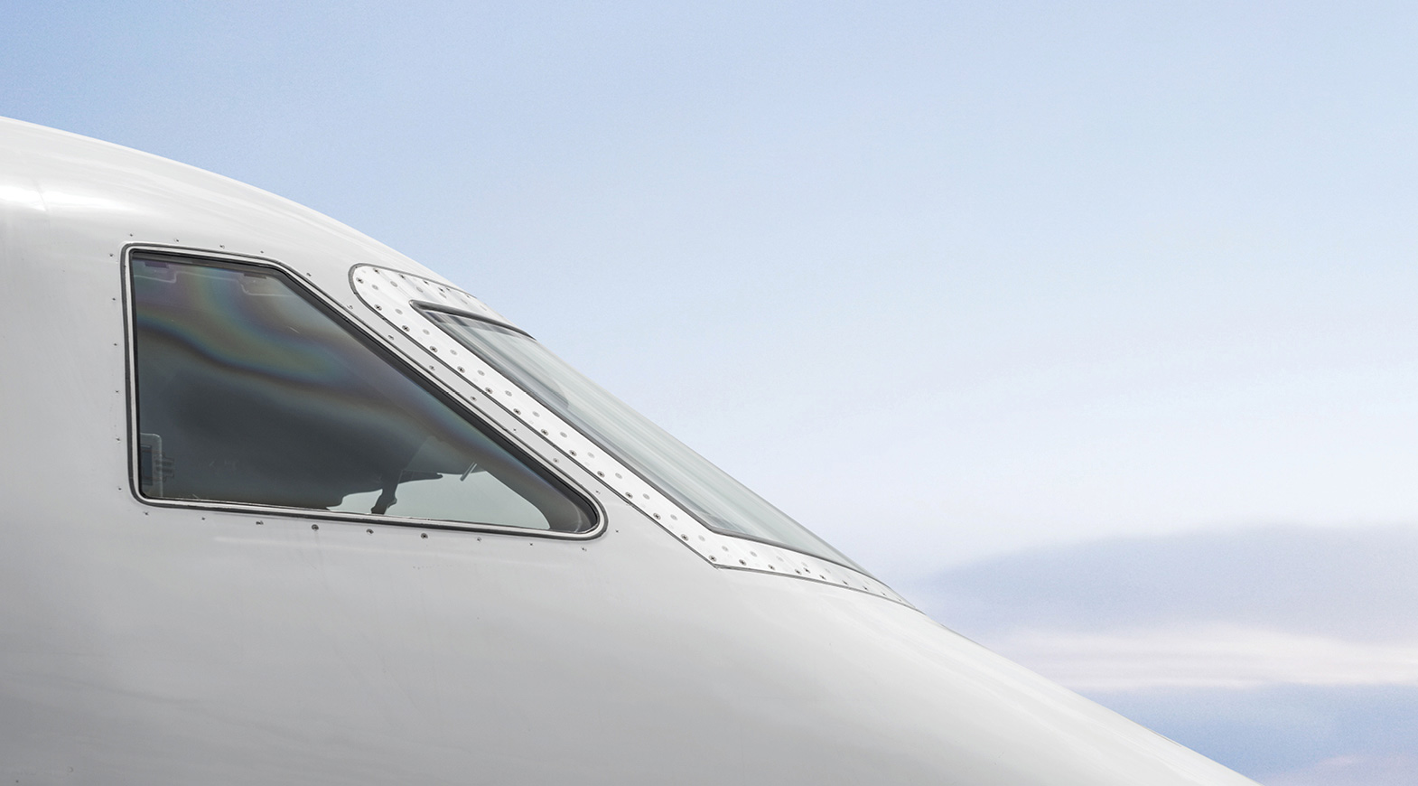 Private jet cockpit window with sky reflection, luxury aviation perspective