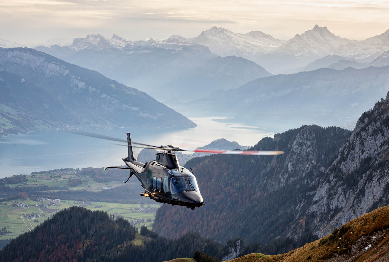 Helicopter flying over alpine mountains aerial transport aviation landscape