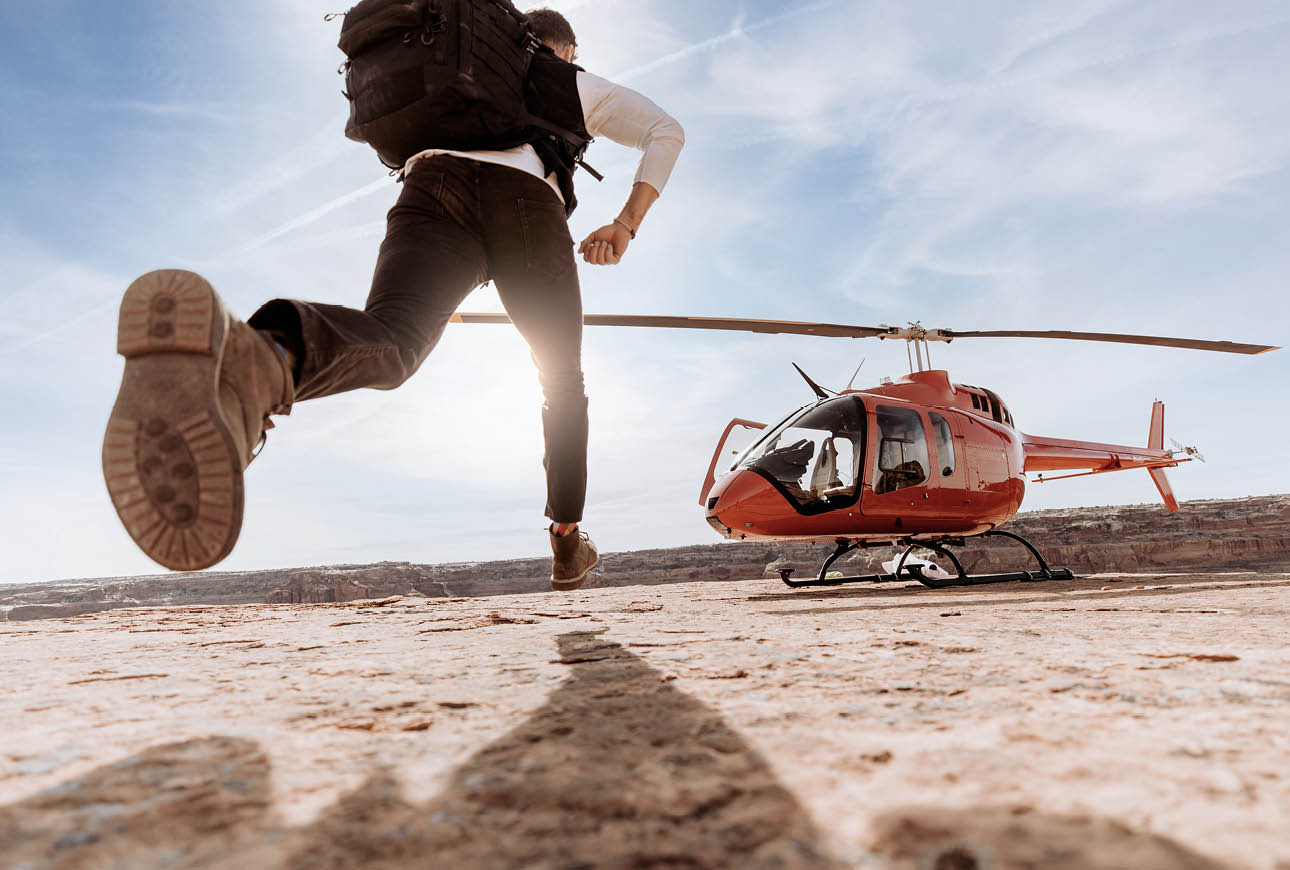 Person approaching red helicopter in desert landscape aviation adventure concept