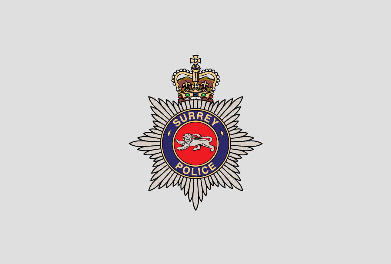 Surrey Police crest badge featuring crown and lion emblem on a star-shaped background